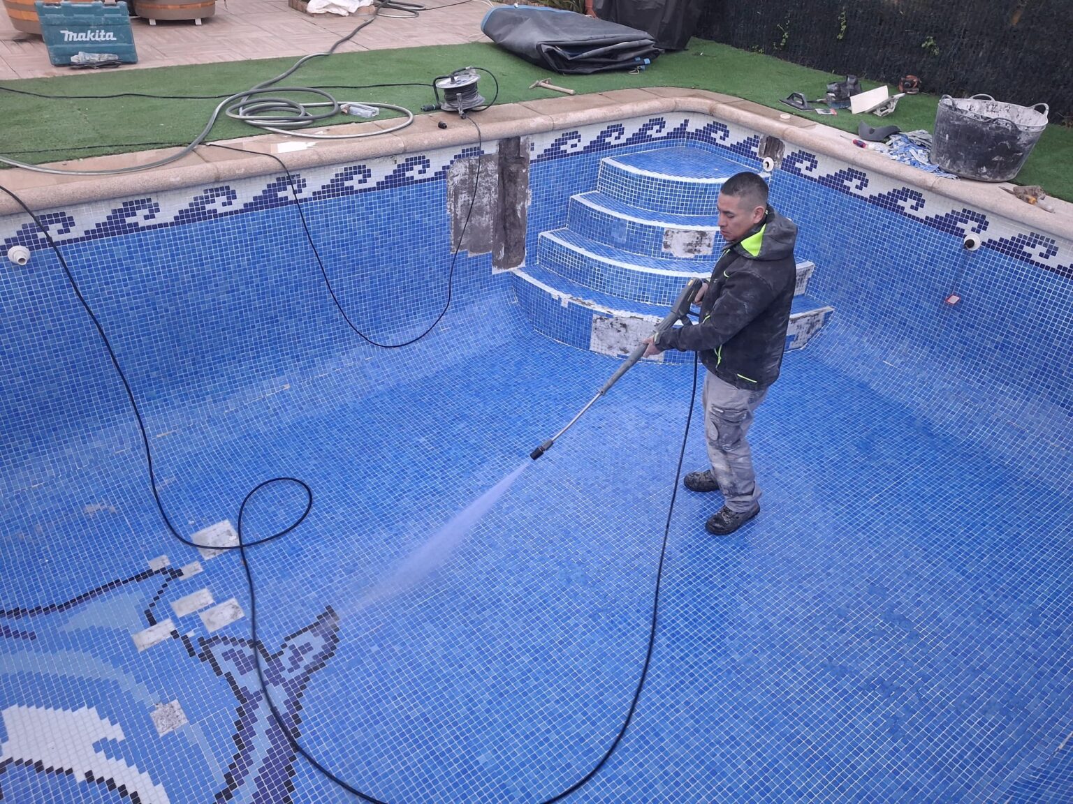 Operario cualificado realizando mediciones de agua en una piscina de Majadahonda.
